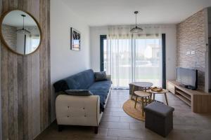 a living room with a blue couch and a mirror at La casa du lac vue imprenable in Homps
