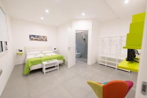 una camera bianca con un letto e una sedia gialla di White houses luxury and pool a Scoglitti Altre 69 foto