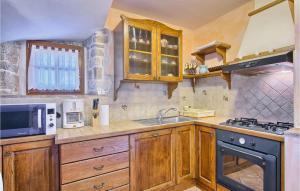 a kitchen with wooden cabinets and a stove top oven at Villa Stancija Bursic in Pula