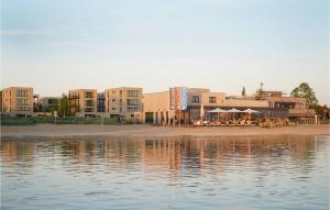 a group of buildings next to a body of water at Nice Home In Lembruchdümmer See in Lembruch