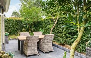 a wooden table with wicker chairs on a patio at 3 Bedroom Nice Home In Vlagtwedde in Vlagtwedde +27 photos