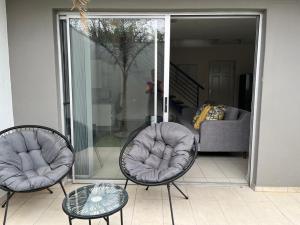 a patio with two chairs and a table and a couch at City Sanctuary Trift Towers in Windhoek