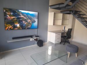 a living room with a tv hanging on the wall at City Sanctuary Trift Towers in Windhoek