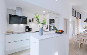 a kitchen with white cabinets and a table at Beach Front Home In Lembruchdümmer See in Lembruch
