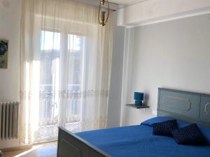 a bedroom with a blue bed and a window at Il Lupo e la Volpe in Centobuchi +12 photos