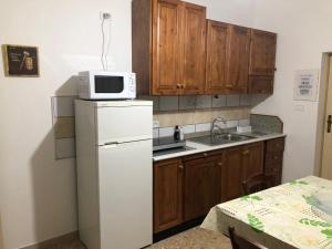 a kitchen with a white refrigerator and a microwave at Il Lupo e la Volpe in Centobuchi