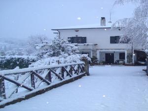 a house with a fence covered in snow at B&B Sole del Pollino in Rotonda