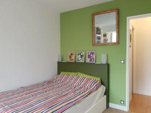 パリにあるAlesia - Plantesのベッドルーム1室(壁に鏡付きのベッド1台付)