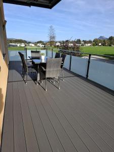 a patio with a table and chairs on a deck at Ferienwohnung Wallner in Hof bei Salzburg
