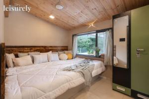 un grand lit dans une chambre avec une fenêtre dans l'établissement Stay Leisurely Pawna Lake Villa 3BHK, Pawna Lake, à Malavli 24 autres photos
