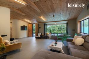 un salon avec un canapé et une table dans l'établissement Stay Leisurely Pawna Lake Villa 3BHK, Pawna Lake, à Malavli