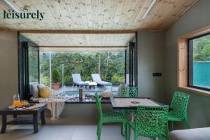 une pièce avec une table, des chaises et une fenêtre dans l'établissement Stay Leisurely Pawna Lake Villa 3BHK, Pawna Lake, à Malavli
