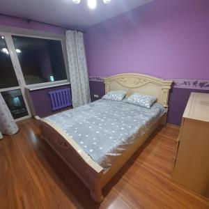una camera da letto con un letto con pareti viola e una finestra di 2-х комнатная квартира в центре a Karagandy Altre 27 foto