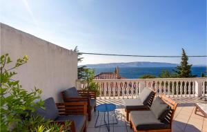 a patio with chairs and tables on a balcony at Awesome Home In Senj With Kitchen in Senj +31 photos