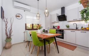 a kitchen with a wooden table and green chairs at Awesome Home In Senj With Kitchen in Senj