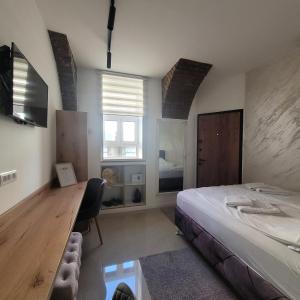 a bedroom with a bed and a desk and a window at Dream House in Novi Sad