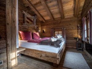 ein Schlafzimmer mit einem Bett in einer Blockhütte in der Unterkunft Buccara Zwischenbachalm in Westendorf