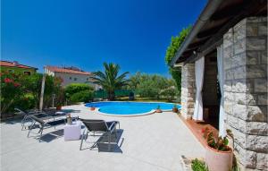 プーラにあるVilla Beautyの椅子とプールのあるパティオ