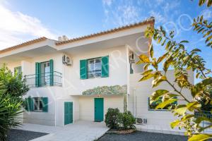a white house with green shutters at Villa Ferragudo in Ferragudo