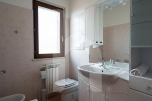 a white bathroom with a sink and a toilet at Homiday - Villa Mila in Pineto +45 photos
