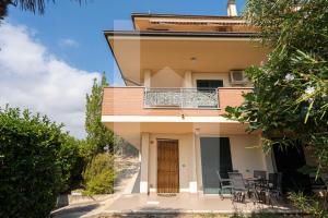 a house with a balcony with a table and chairs at Homiday - Villa Mila in Pineto