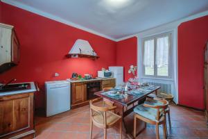 a kitchen with red walls and a table and chairs at Mila Bike with wi-fi - Happy Rentals in Premeno