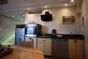 a kitchen with a table and a stove and a refrigerator at Mirage House in Mirleft +15 photos