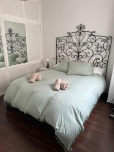Una cama con dos zapatillas rosas encima. en Alcalá zona Centro, en Alcalá la Real