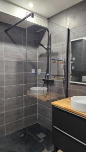 a bathroom with a glass shower and a sink at Appartement cozy 2 chambres in Luchon +8 photos