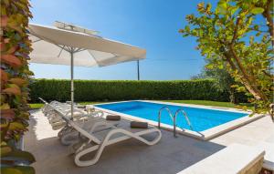 a group of lounge chairs and an umbrella next to a pool at Villa Marasi in Poreč +49 photos