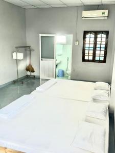 a room with a large white bed and a bathroom at Home Sun Moon - Home 4 in Phan Thiet