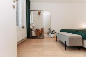 a bedroom with a mirror and a bed and a chair at ZILTE STILTE in Ostend +45 photos