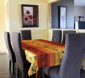 una sala da pranzo con tavolo, sedie e tavolo di Hébergement Italia a La Tuque Altre 6 foto