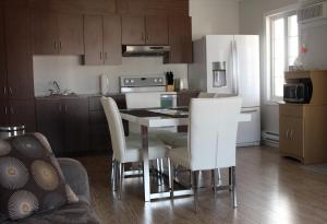 a kitchen with a table and chairs in a room at Hébergement Italia in La Tuque