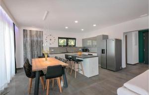 a kitchen with a table and chairs and a refrigerator at Villa Althea in Ružići