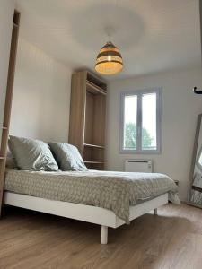 Un dormitorio con una cama grande con ventana. en Maison de ville plein centre, en Saint-Céré