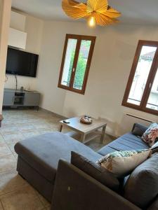 una sala de estar con un sofá y una mesa en Maison de ville plein centre, en Saint-Céré