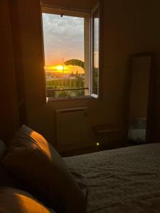 Un dormitorio con una cama y una ventana con la puesta de sol. en Maison de ville plein centre, en Saint-Céré