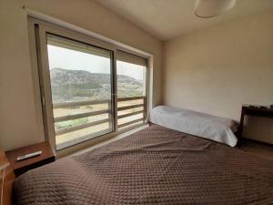 une chambre avec un lit et une grande fenêtre dans l'établissement Mari-luna, à Siculiana Marina