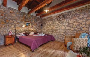 a bedroom with a bed and a stone wall at Awesome Home In Novi Vinodolski in Novi Vinodolski