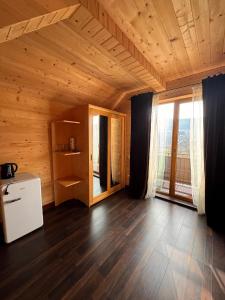 a room with a wooden ceiling and a large window at Опришок in Palyanytsya