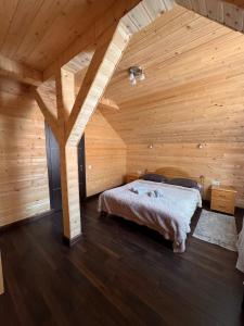 a bedroom with a bed in a wooden room at Опришок in Palyanytsya