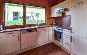 a kitchen with white cabinets and a sink and a window at 2 Bedroom Awesome Home In Boiensdorf in Boiensdorf
