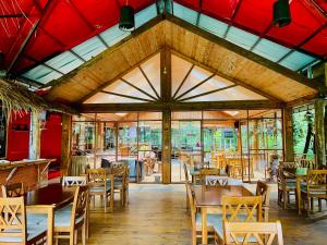 a restaurant with wooden tables and chairs and a red ceiling at King Fern Cottage in Nuwara Eliya
