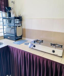 a stove top on a table with a purple skirt at Ila Homestay in Senawang +10 photos