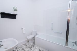 a white bathroom with a toilet and a sink at Amber Hotel in Hull