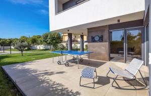 a ping pong table and two chairs on a patio at Villa Hedone Rakalj in Krasa