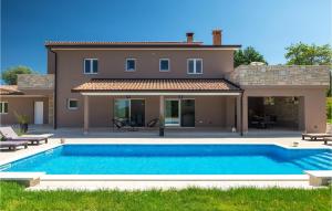 a villa with a swimming pool in front of a house at Villa Zamari in Zarečje