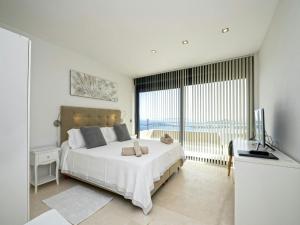 Un dormitorio con una cama y una ventana grande. en Villa in Ibiza with Panoramic Sea Views, en Nuestra Señora de Jesús