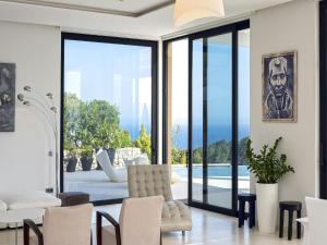 sala de estar con puertas de cristal y vistas a la piscina en Villa in Ibiza with Panoramic Sea Views, en Nuestra Señora de Jesús